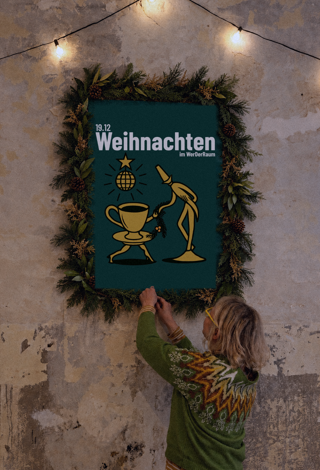 Das Plakat „Weihnachten im WerDerRaum, 19.12.“ mit Tannenkranz wird an der alten Wand aufgehängt, darüber eine Lichterkette